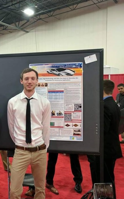 Dylan Jubinville standing in front of his SPE ACCE poster.